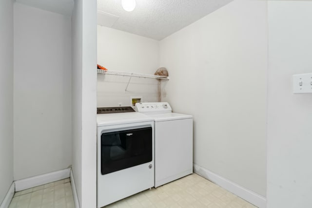 laundry area with a textured ceiling, laundry area, baseboards, washer and dryer, and light floors