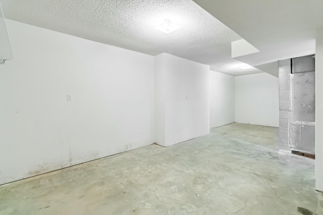 spare room with unfinished concrete flooring and a textured ceiling