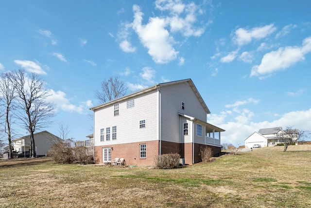 view of side of home featuring a yard and brick siding