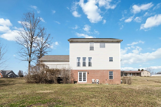 back of house with brick siding, a lawn, and a wooden deck