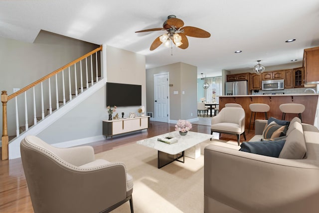 living area featuring recessed lighting, stairway, a ceiling fan, light wood-type flooring, and baseboards