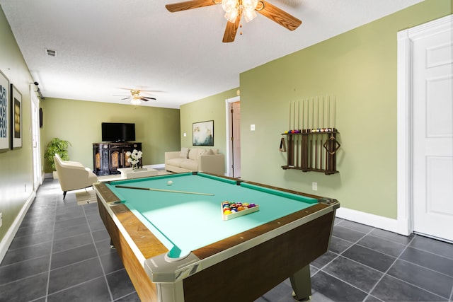 recreation room featuring ceiling fan, a textured ceiling, dark tile patterned floors, visible vents, and baseboards