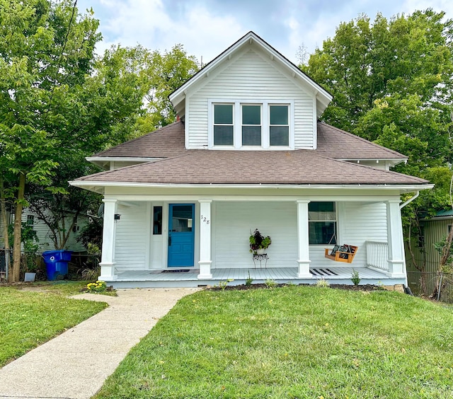 view of front of home featuring a shingled roof, a front lawn, and a porch