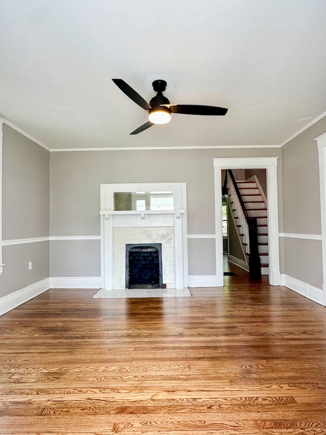 unfurnished living room with crown molding, a fireplace, and wood finished floors