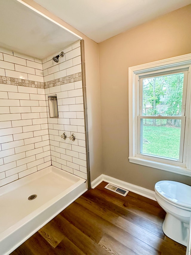 full bath featuring visible vents, toilet, a stall shower, wood finished floors, and baseboards