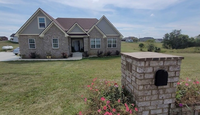 craftsman house featuring brick siding and a front lawn