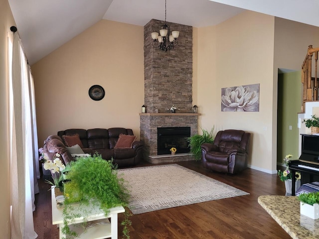 living room with high vaulted ceiling, dark wood finished floors, a stone fireplace, baseboards, and a chandelier