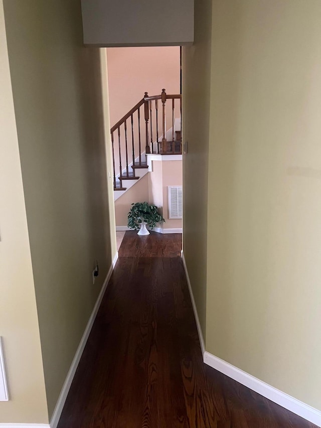 corridor with visible vents, stairs, baseboards, and wood finished floors