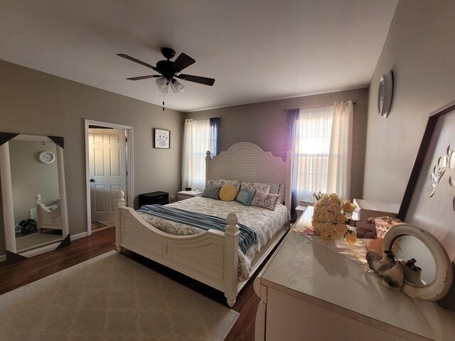 bedroom with wood finished floors, a closet, and baseboards