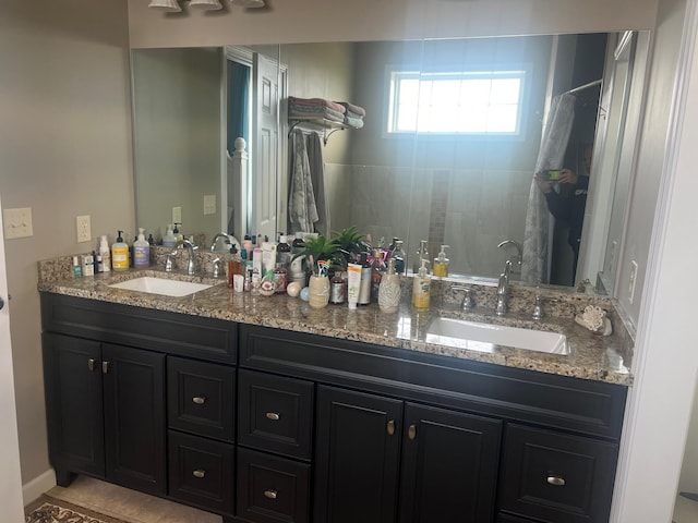 bathroom with a sink, double vanity, and a tile shower