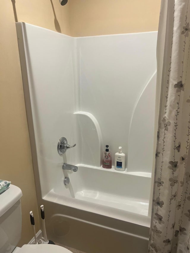 bathroom featuring toilet and shower / tub combo with curtain