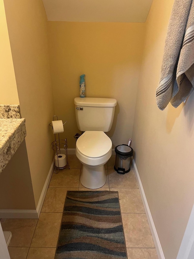 bathroom featuring baseboards, toilet, and tile patterned flooring