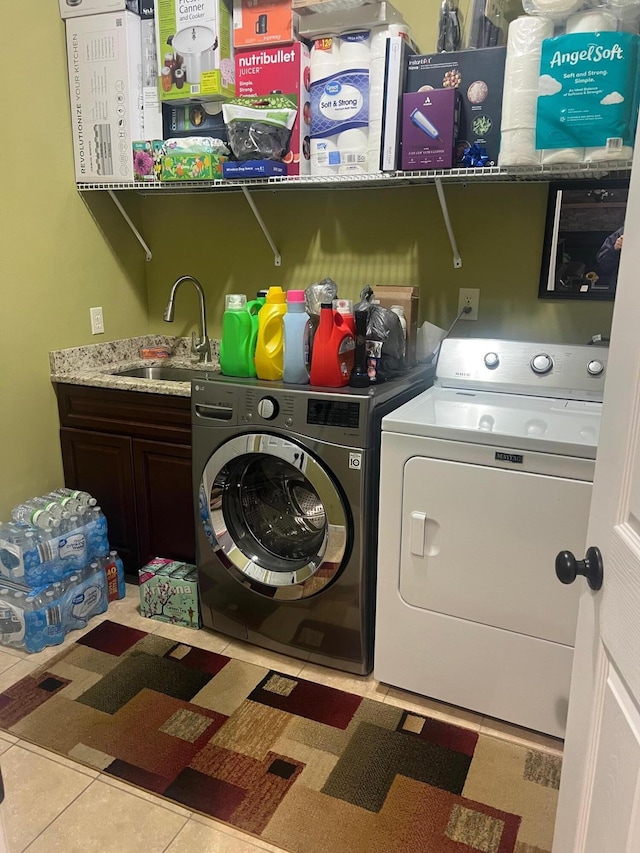 clothes washing area with tile patterned flooring, independent washer and dryer, cabinet space, and a sink