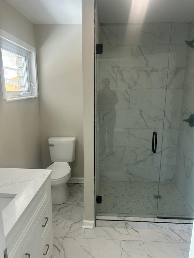 bathroom featuring marble finish floor, a marble finish shower, toilet, vanity, and baseboards