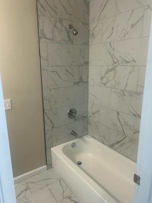 bathroom with shower / bathtub combination, marble finish floor, and baseboards