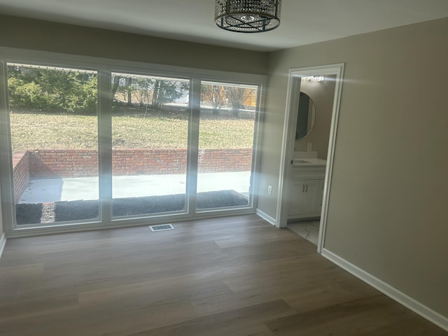 entryway featuring visible vents, baseboards, and wood finished floors