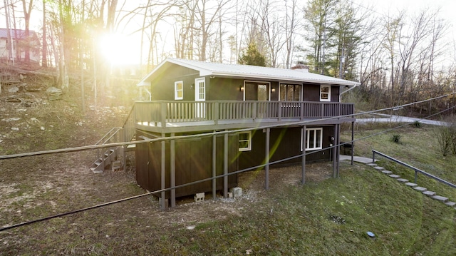 exterior space featuring stairs, stucco siding, a chimney, metal roof, and a deck