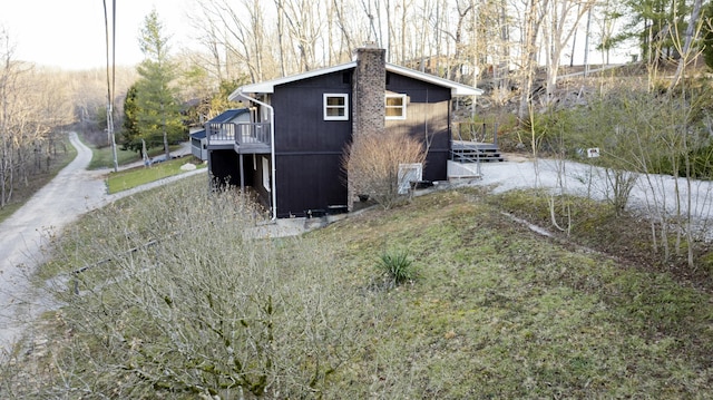 view of property exterior featuring a chimney and a deck