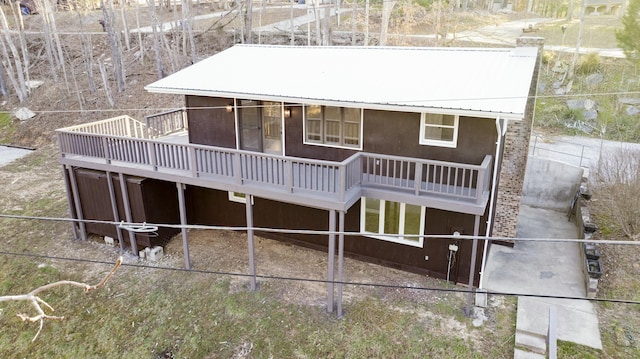 back of property with metal roof and a wooden deck