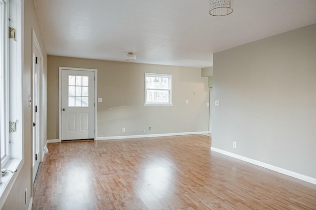 entryway with light wood finished floors and baseboards