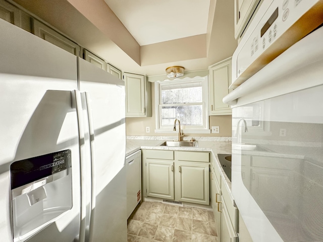 kitchen featuring light countertops, fridge with ice dispenser, visible vents, and a sink