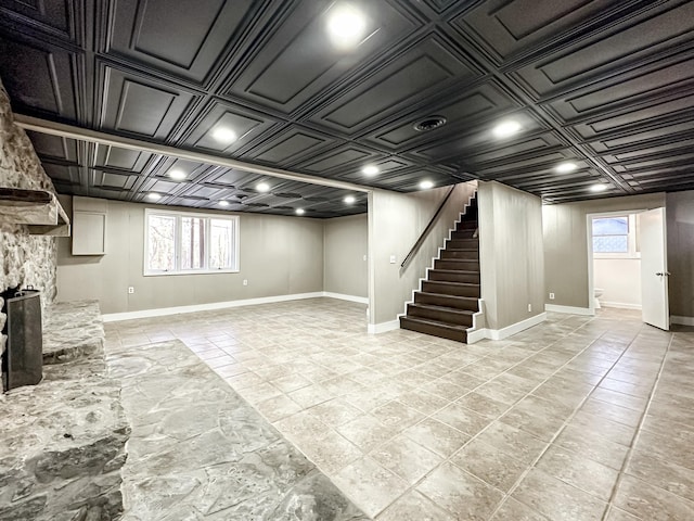 basement featuring stairs, a healthy amount of sunlight, baseboards, and an ornate ceiling