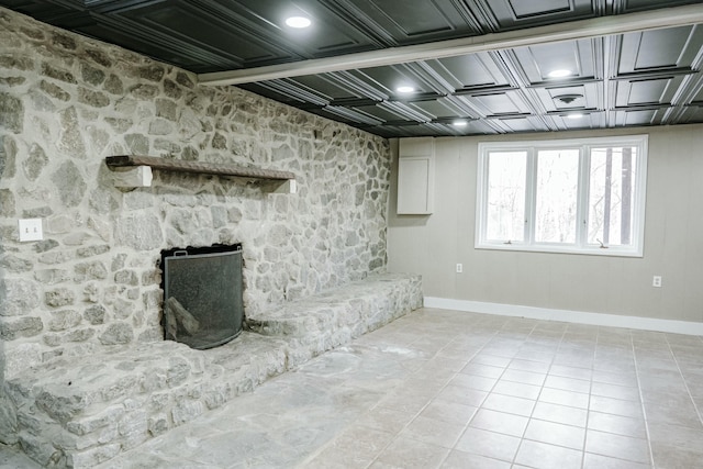 basement featuring tile patterned floors and baseboards