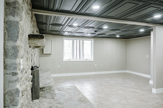 basement featuring light tile patterned floors and baseboards