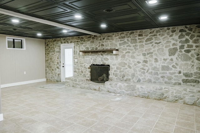 basement featuring tile patterned flooring and a fireplace