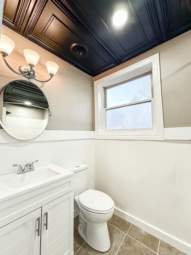 bathroom featuring vanity, tile patterned floors, toilet, and baseboards