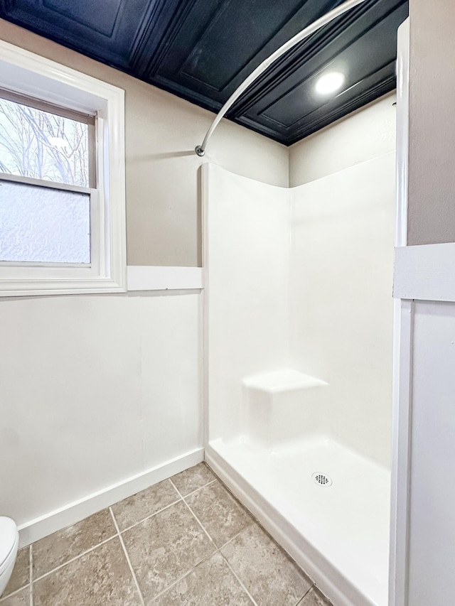 full bathroom with toilet, baseboards, and walk in shower