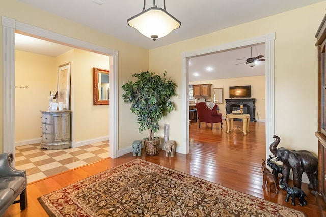 interior space with light wood-type flooring, a ceiling fan, and baseboards