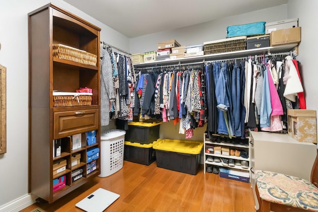 walk in closet with wood finished floors