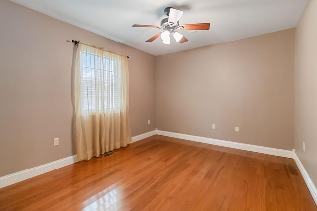 unfurnished room featuring baseboards, ceiling fan, visible vents, and light wood-style floors