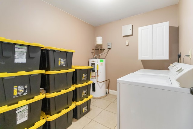 clothes washing area with cabinet space, light tile patterned floors, baseboards, water heater, and separate washer and dryer