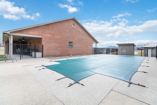 view of pool with a fenced in pool, a patio, an outbuilding, a gate, and fence