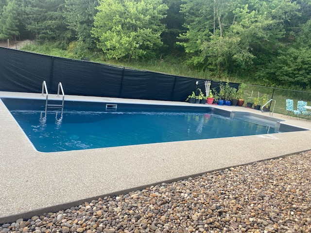 view of pool with a fenced in pool and fence