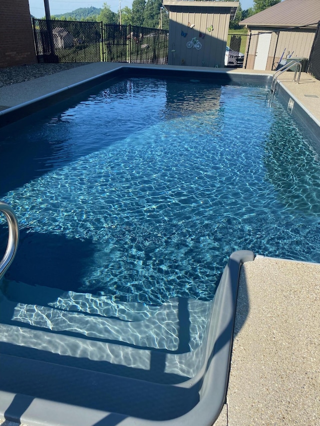 view of pool with an outbuilding, fence, and a fenced in pool