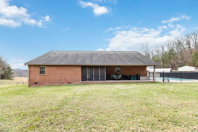 back of property featuring crawl space, a yard, a sunroom, and brick siding