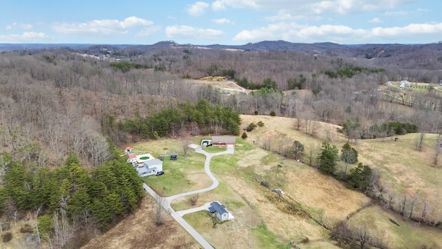 birds eye view of property featuring a wooded view and a mountain view