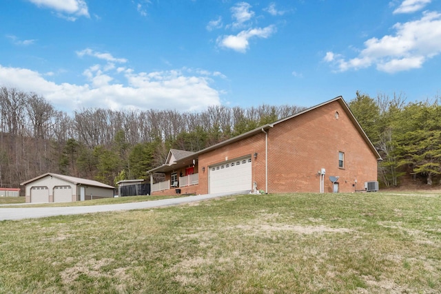 view of home's exterior featuring central AC, a lawn, and brick siding