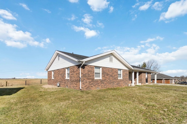 view of home's exterior with a yard, fence, and brick siding