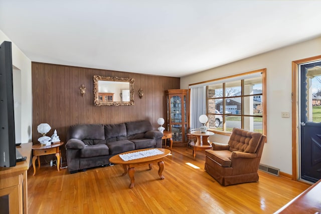 living room with visible vents, baseboards, and wood finished floors