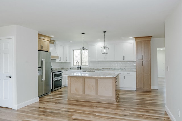 kitchen featuring premium range hood, light wood finished floors, a kitchen island, appliances with stainless steel finishes, and backsplash