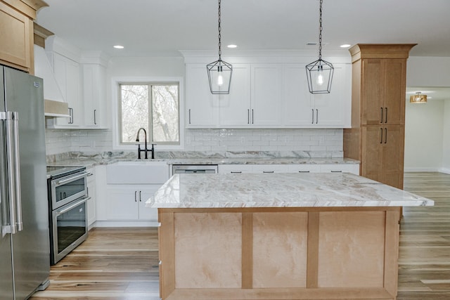 kitchen with stainless steel appliances, backsplash, hanging light fixtures, and light wood finished floors