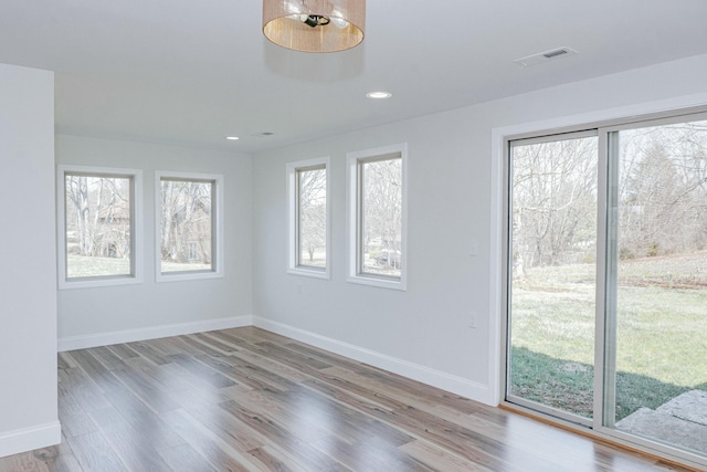 empty room featuring recessed lighting, visible vents, baseboards, and wood finished floors