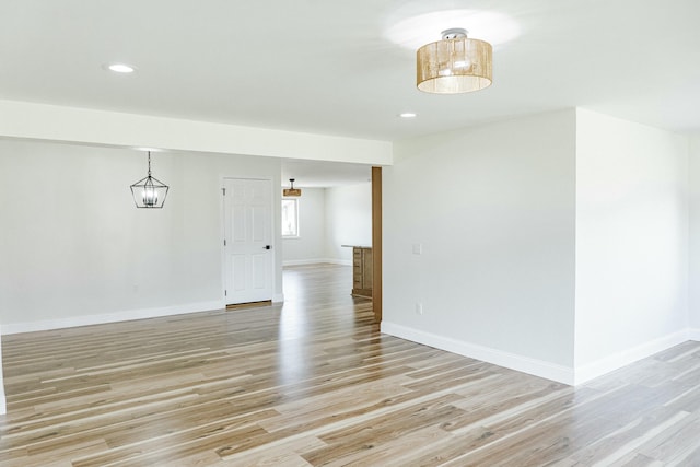 empty room featuring recessed lighting, baseboards, and light wood-style floors