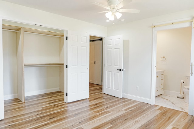 unfurnished bedroom with light wood-style flooring, baseboards, a closet, and ensuite bathroom