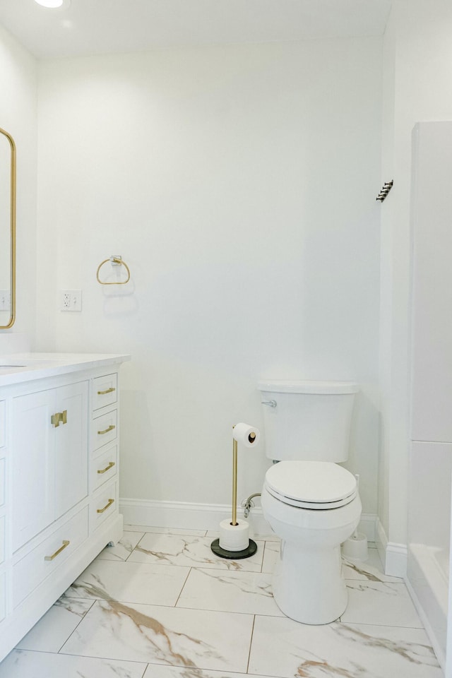 full bath with marble finish floor, toilet, vanity, and baseboards