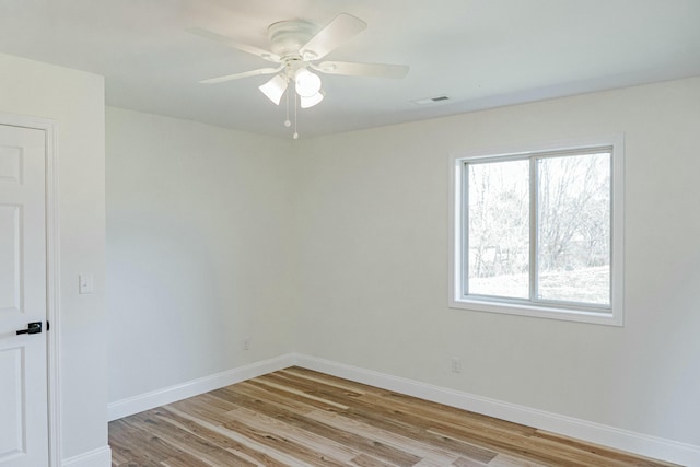 empty room with visible vents, baseboards, light wood-style floors, and ceiling fan